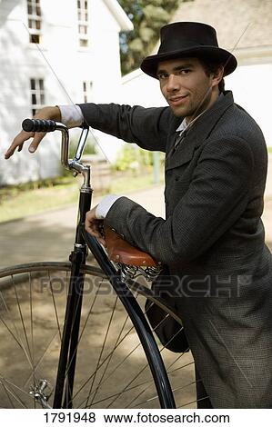 Stock Photo - Man in period costume with an antique unicycle. Fotosearch