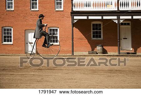 Man riding antique bicycle View Large Photo Image Stock Photo - Man riding antique bicycle. Fotosearch