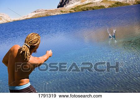 Man skipping rocks in water Stock Photo | 1791319 | Fotosearch