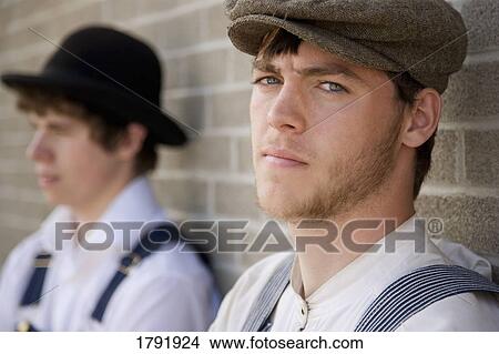 Men in old-fashioned clothing standing against a brick wall View Large Photo Image Picture - Men in old-fashioned clothing standing against a brick wall. Fotosearch