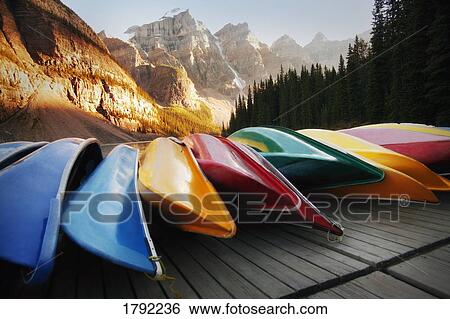 Multi-colored canoes resting on a dock View Large Photo Image Stock Photograph - Multi-colored canoes resting on a dock. Fotosearch