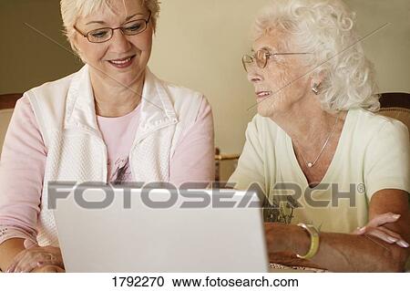 Stock Image - Older women working on computer. Fotosearch