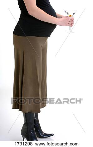 Pregnant woman holding a martini View Large Photo Image Stock Photo - Pregnant woman holding a martini. Fotosearch