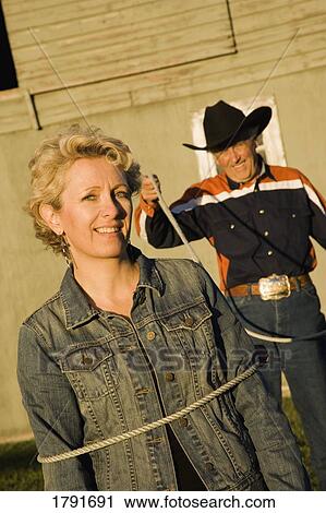 Rancher lassoing woman View Large Photo Image Stock Image - Rancher lassoing woman. Fotosearch