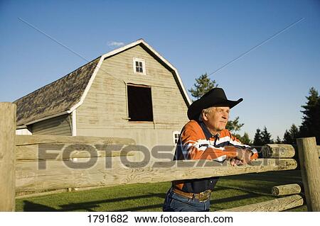 Rancher leaning on a corral View Large Photo Image Stock Image - Rancher leaning on a corral. Fotosearch