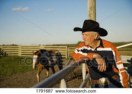 Rancher leaning on a corral View Large Photo Image Stock Photo - Rancher leaning on a corral. Fotosearch