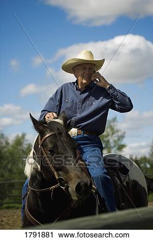 Rancher talking on a cell phone View Large Photo Image Stock Image - Rancher talking on a cell phone. Fotosearch