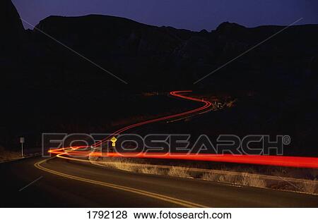 Streaking car tail lights on road at night View Large Photo Image Stock Photo - Streaking car tail lights on road at night. Fotosearch
