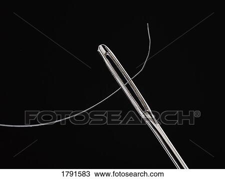 Stock Image - Thread through eye of needle. Fotosearch
