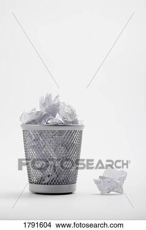 Picture - Trash can overflowing with paper. Fotosearch