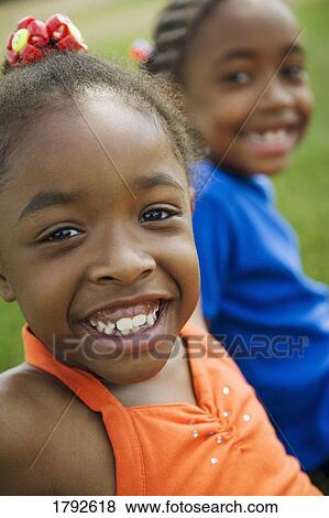 Two girls sitting outside View Large Photo Image Stock Photo - Two girls sitting outside. Fotosearch