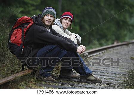 Two hikers sitting on railroad tracks View Large Photo Image Stock Photograph - Two hikers sitting on railroad tracks. Fotosearch