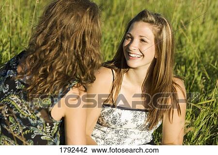 Stock Image - Two young women talking. Fotosearch