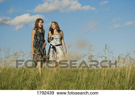 Stock Photo - Two young women walking in field. Fotosearch