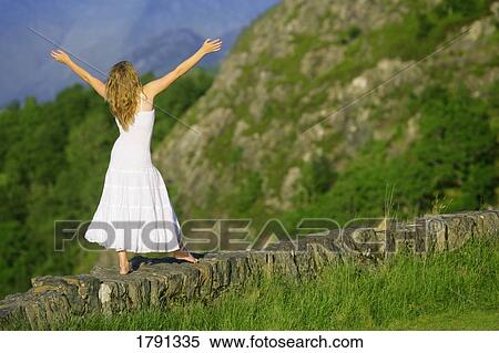 Woman balancing on rock wall ledge View Large Photo Image Stock Photography - Woman balancing on rock wall ledge. Fotosearch
