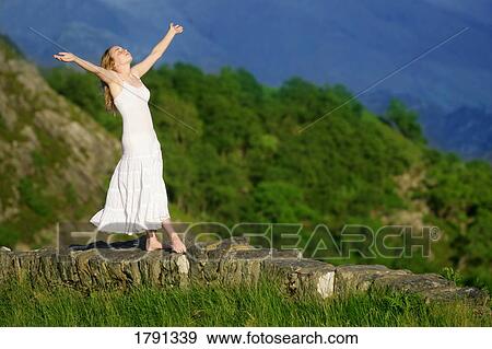 Woman balancing on rock wall ledge with eyes closed View Large Photo Image Stock Photo - Woman balancing on rock wall ledge with eyes closed. Fotosearch