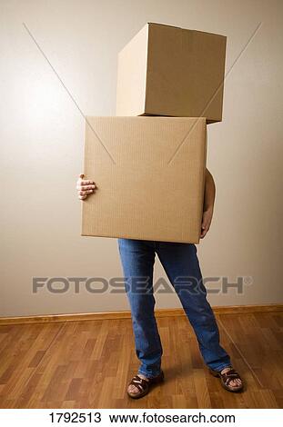 Stock Image - Woman carrying heavy boxes. Fotosearch