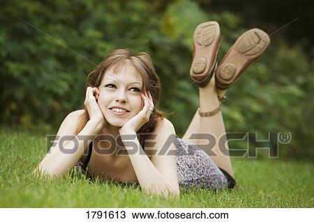Woman laying on grass View Large Photo Image Stock Image - Woman laying on grass. Fotosearch