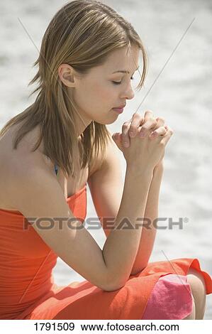 Stock Photo - Woman praying at beach. Fotosearch