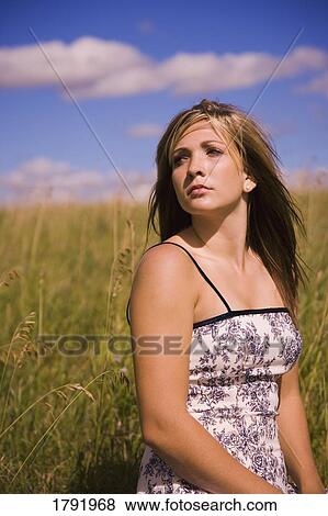 Woman sitting in a field View Large Photo Image Stock Photo - Woman sitting in a field. Fotosearch