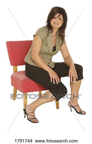 Woman sitting on a red chair View Large Photo Image Picture - Woman sitting on a red chair. Fotosearch