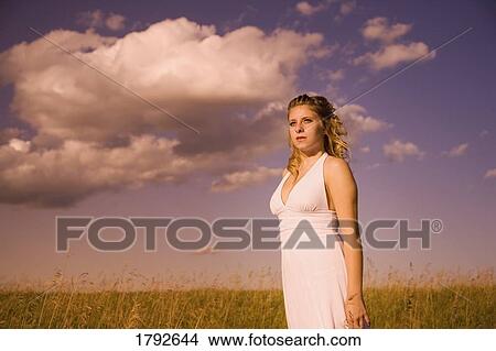 Woman standing in field View Large Photo Image Picture - Woman standing in field. Fotosearch