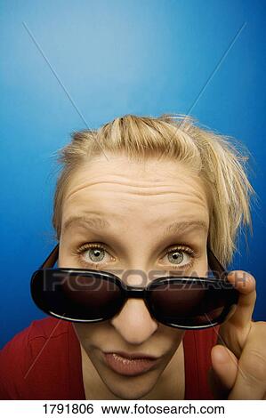 Woman wearing sunglasses with humorous facial expression View Large Photo Image Stock Photograph - Woman wearing sunglasses with humorous facial expression. Fotosearch