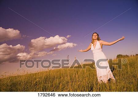 Stock Photograph - Woman worshiping in a field. Fotosearch
