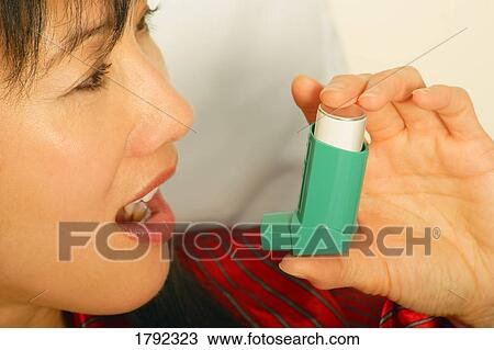 Stock Image - Women using inhaler. Fotosearch