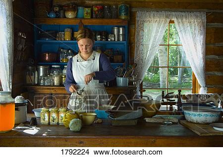Picture - young lady baking in the 1800's. Fotosearch