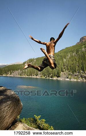 Young man jumping into lake View Large Photo Image Stock Photo - Young man jumping into lake. Fotosearch