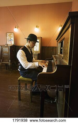Stock Photo - Young man playing piano. Fotosearch
