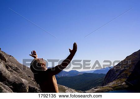 Young man worshipping on mountain top View Large Photo Image Stock Photography - Young man worshipping on mountain top. Fotosearch
