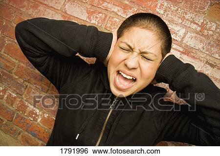Young woman covering ears and screaming View Large Photo Image Stock Photograph - Young woman covering ears and screaming. Fotosearch