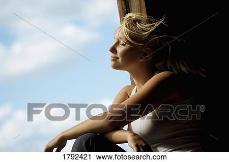 Stock Image - Young woman enjoying breeze. Fotosearch