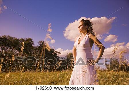 Stock Image - Young woman in field. Fotosearch