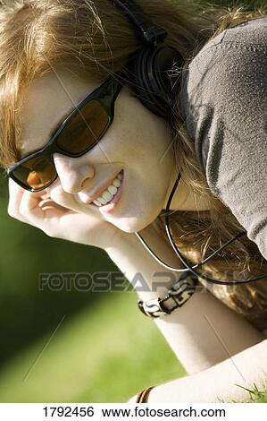 Young woman listening to music View Large Photo Image Stock Photograph - Young woman listening to music. Fotosearch