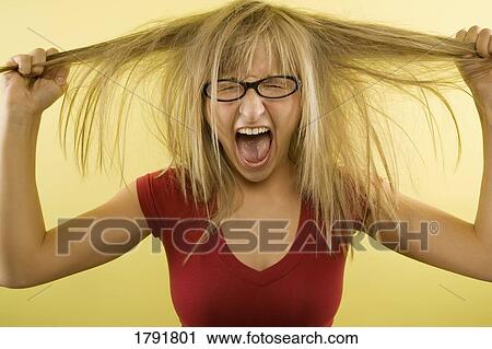 Young woman pulling her hair out View Large Photo Image Stock Image - Young woman pulling her hair out. Fotosearch