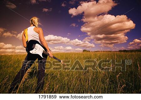 Stock Photo - Young woman with electric guitar. Fotosearch