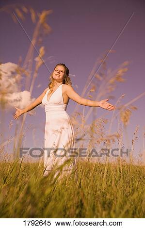 Young woman worshipping in a field View Large Photo Image Stock Photography - Young woman worshipping in a field. Fotosearch