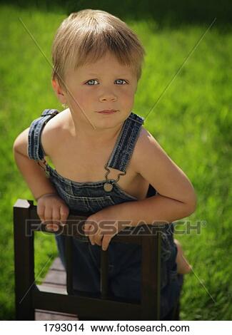 Picture - Boy leaning on chair. Fotosearch