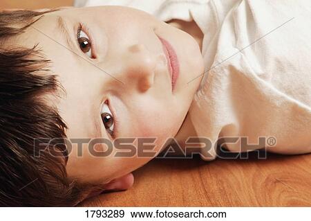 Boy lying on the floor View Large Photo Image Stock Photo - Boy lying on the floor. Fotosearch