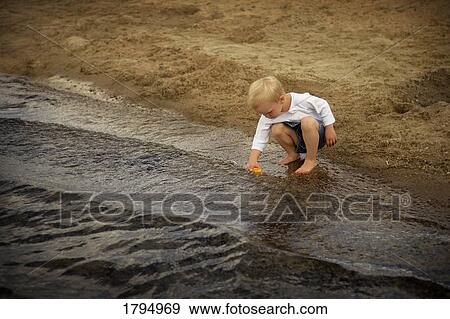 Boy playing at the beach View Large Photo Image Stock Photo - Boy playing at the beach. Fotosearch