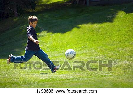 Stock Photograph - Boy playing soccer. Fotosearch