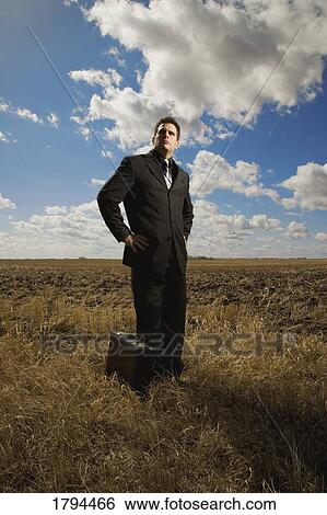 Stock Photograph - Business man in open field. Fotosearch