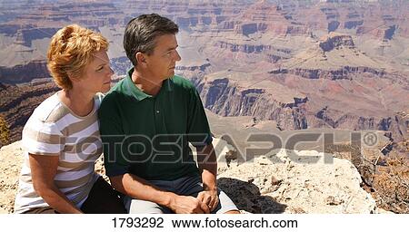 Couple looking out at over canyon View Large Photo Image Stock Image - Couple looking out at over canyon. Fotosearch