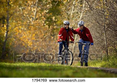 Couple riding bikes View Large Photo Image Stock Photo - Couple riding bikes. Fotosearch