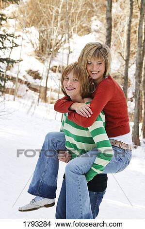 Picture - Daughter giving mom piggyback. Fotosearch