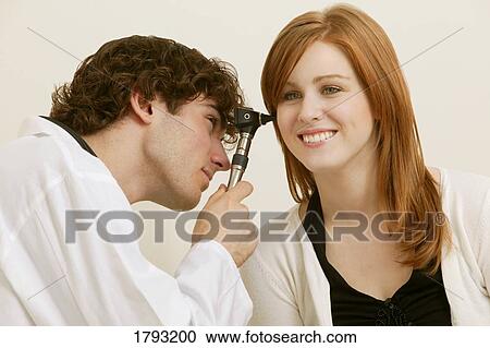 Stock Image - Doctor examining young woman. Fotosearch