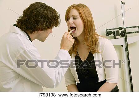 Doctor examining young woman View Large Photo Image Stock Photo - Doctor examining young woman. Fotosearch